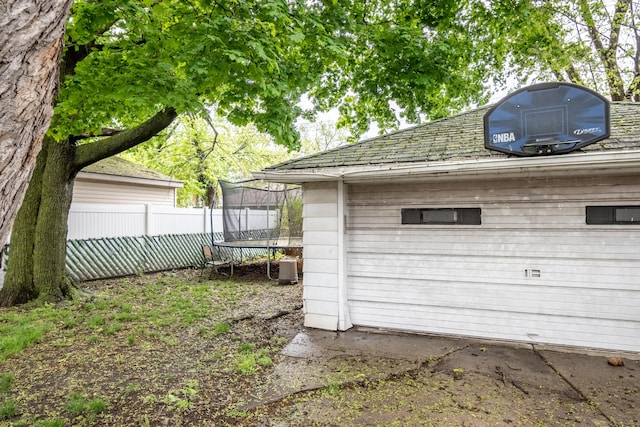garage featuring a trampoline and fence