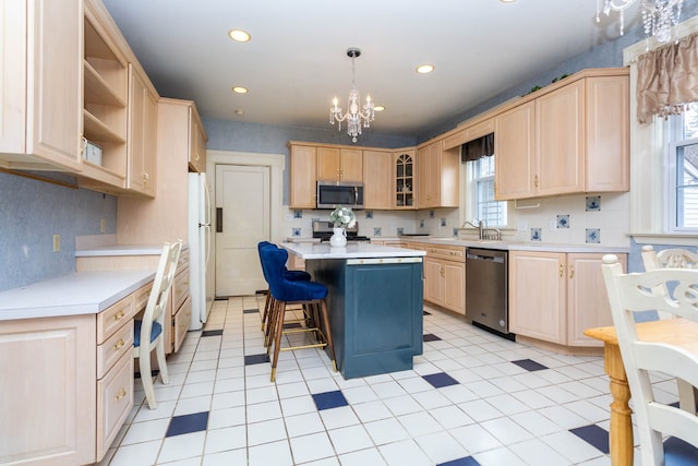 kitchen with stainless steel appliances, light brown cabinets, a sink, light countertops, and recessed lighting
