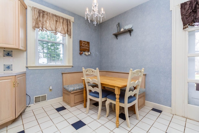 dining space featuring a chandelier, light tile patterned floors, and baseboards