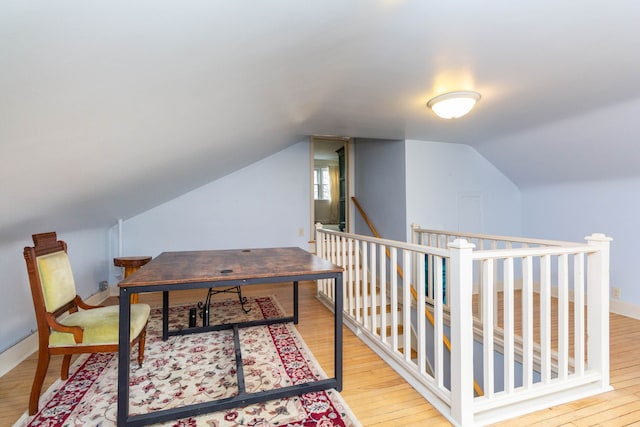 office featuring wood finished floors, lofted ceiling, and baseboards