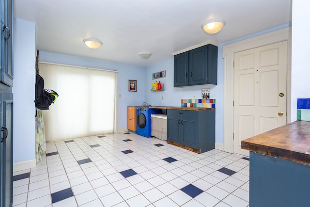 kitchen featuring blue cabinetry, wooden counters, and baseboards