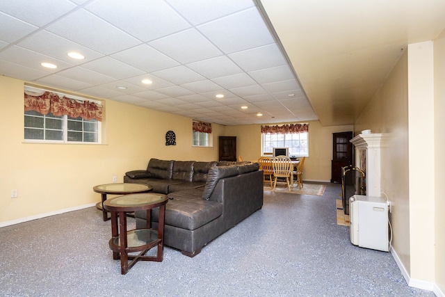 living room featuring baseboards, recessed lighting, and a paneled ceiling
