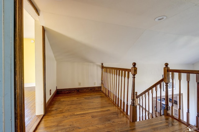 additional living space featuring hardwood / wood-style floors, baseboards, and vaulted ceiling
