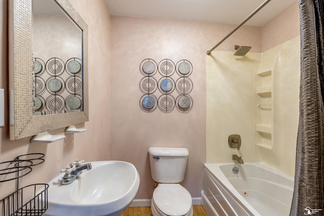 bathroom featuring toilet, a sink, and shower / bathing tub combination
