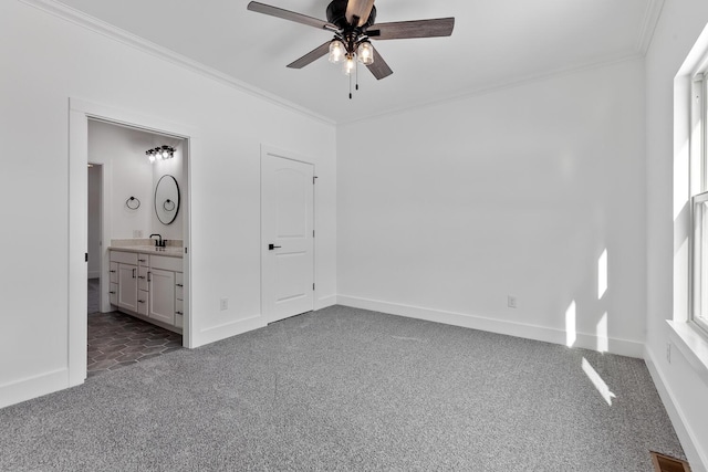 unfurnished bedroom with crown molding, carpet floors, baseboards, and a sink