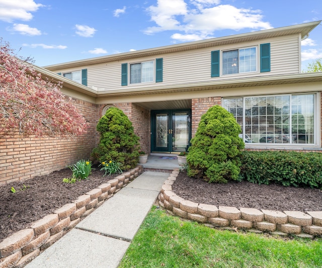 exterior space featuring brick siding and french doors