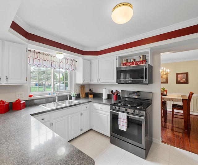 kitchen with crown molding, an inviting chandelier, white cabinetry, a sink, and stainless steel appliances