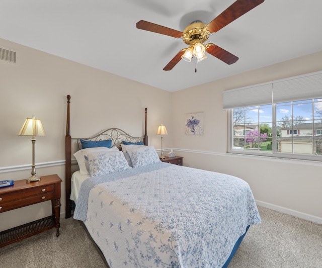 carpeted bedroom featuring a ceiling fan, baseboards, and visible vents