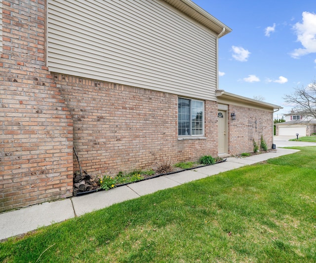 view of home's exterior with a lawn and brick siding