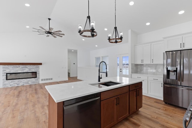 kitchen with visible vents, a sink, open floor plan, light countertops, and appliances with stainless steel finishes