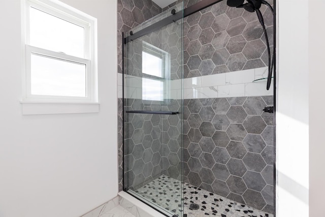 bathroom with a shower stall and marble finish floor
