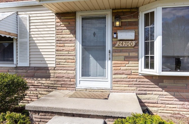 doorway to property with brick siding