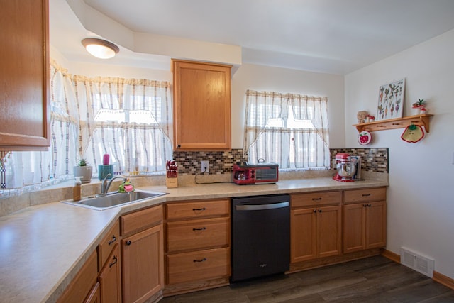 kitchen with a sink, decorative backsplash, dishwasher, dark wood finished floors, and visible vents