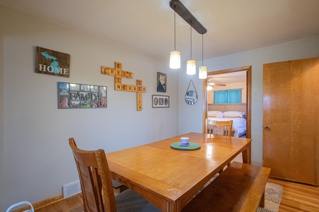 dining area with a ceiling fan, visible vents, and light wood-type flooring