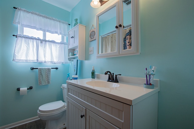 bathroom featuring wood finished floors, toilet, and vanity