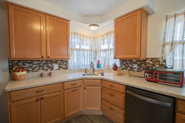 kitchen with light countertops, tasteful backsplash, dishwashing machine, and a sink
