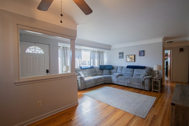 living room with wood finished floors, a ceiling fan, and baseboards