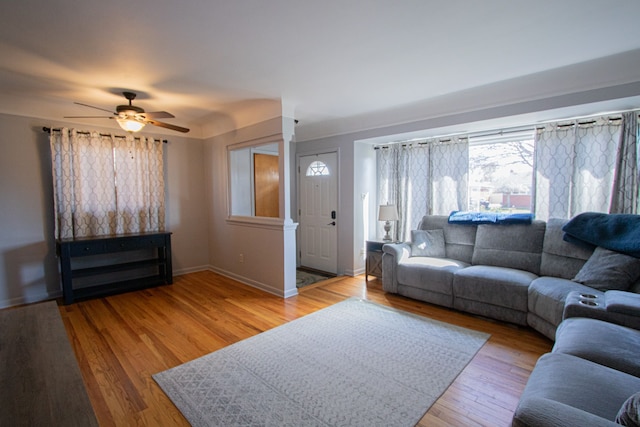 living area with wood finished floors, baseboards, and ceiling fan