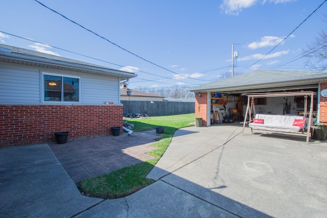 view of property exterior with fence, an outbuilding, brick siding, and a yard