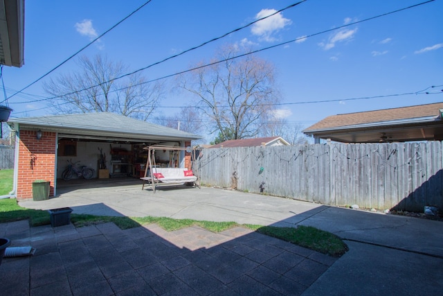 view of yard with a detached garage, an outbuilding, and fence