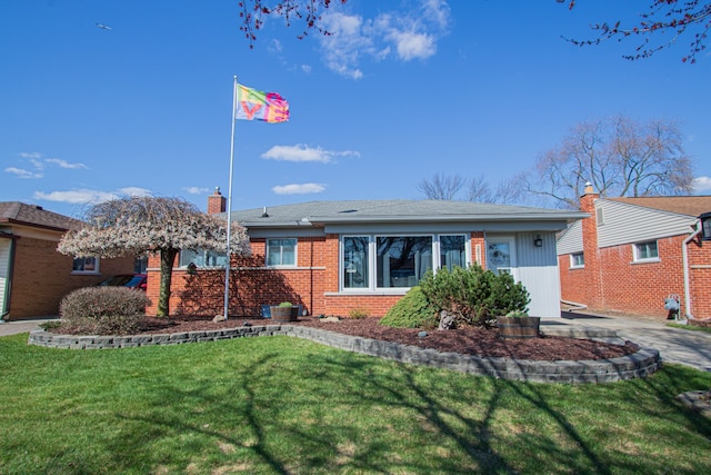 single story home with a chimney, brick siding, and a front yard