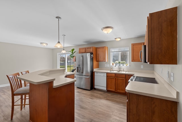 kitchen featuring a sink, appliances with stainless steel finishes, a breakfast bar area, and a wealth of natural light