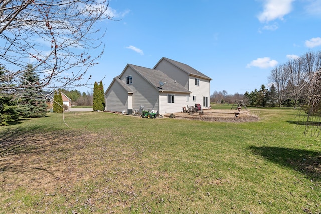 back of property with a lawn and a patio
