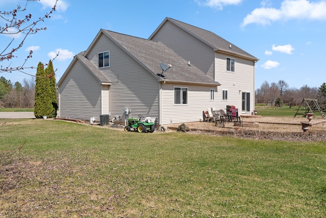 back of property featuring a yard, central AC unit, a patio area, and roof with shingles
