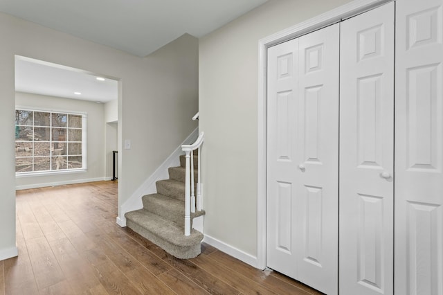 stairway with hardwood / wood-style floors and baseboards