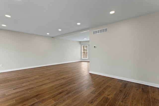 empty room featuring visible vents, baseboards, recessed lighting, and dark wood-style floors