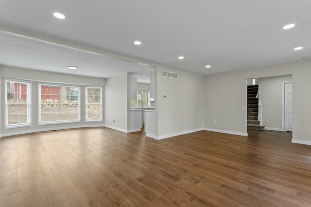 unfurnished living room with baseboards, recessed lighting, stairway, visible vents, and dark wood finished floors