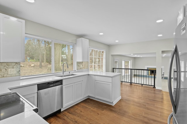 kitchen featuring a sink, light countertops, appliances with stainless steel finishes, recessed lighting, and white cabinetry