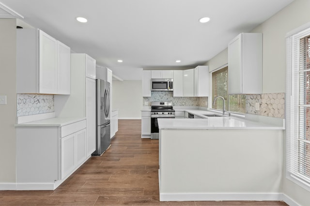 kitchen with a sink, decorative backsplash, appliances with stainless steel finishes, and a healthy amount of sunlight