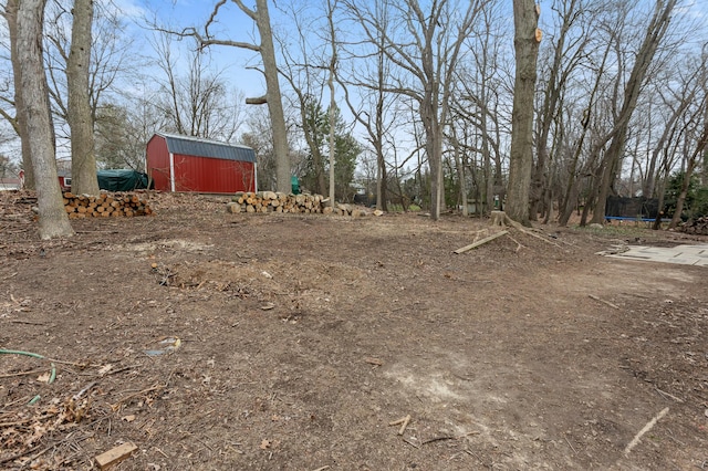 view of yard with a barn, a trampoline, and an outdoor structure