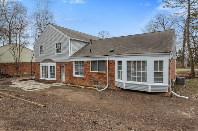 back of house with brick siding, a shingled roof, central AC, and a patio area