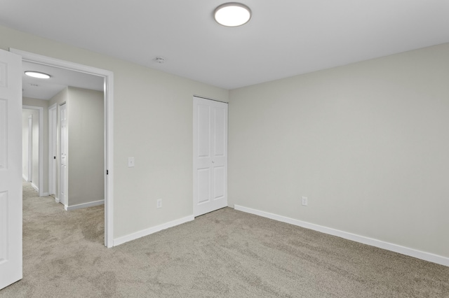 unfurnished bedroom featuring a closet, carpet, and baseboards
