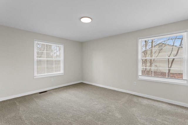 unfurnished room featuring baseboards, visible vents, and carpet floors