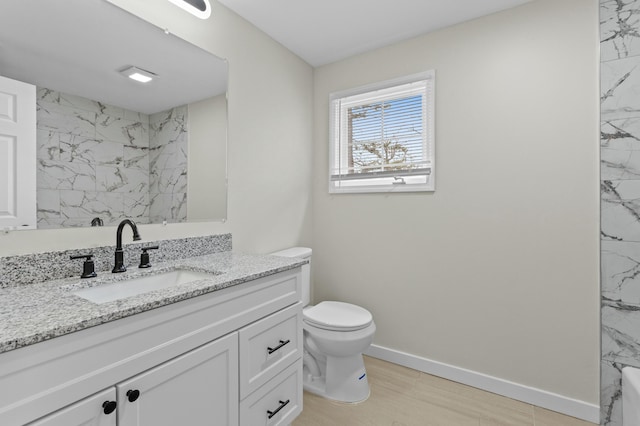full bathroom featuring toilet, vanity, baseboards, and a shower