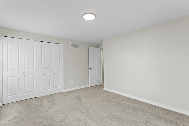 unfurnished bedroom featuring visible vents, baseboards, carpet flooring, and a closet