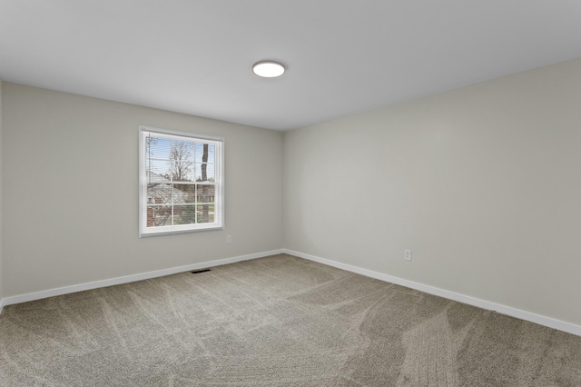 carpeted spare room featuring visible vents and baseboards