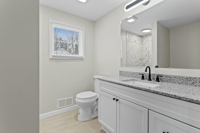 bathroom with vanity, visible vents, toilet, a marble finish shower, and baseboards