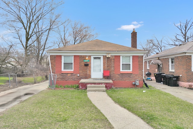 bungalow-style house with fence, a front yard, brick siding, and a chimney