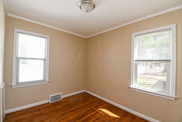 spare room with dark wood-style flooring, baseboards, and crown molding