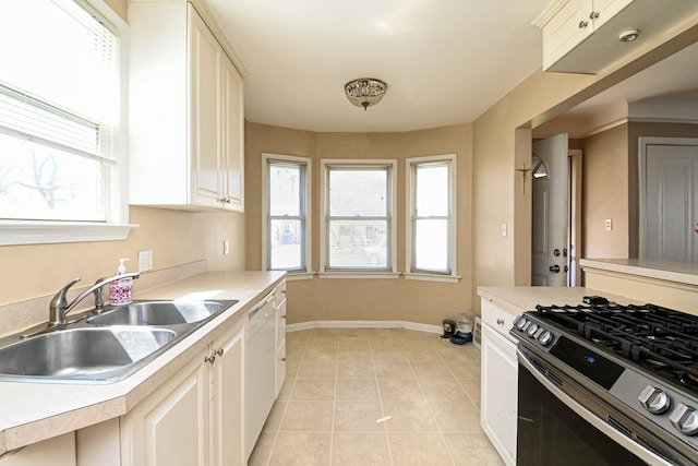 kitchen with stainless steel gas range, a sink, and light countertops