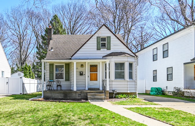 view of front of property with a gate, a porch, a chimney, and a shingled roof