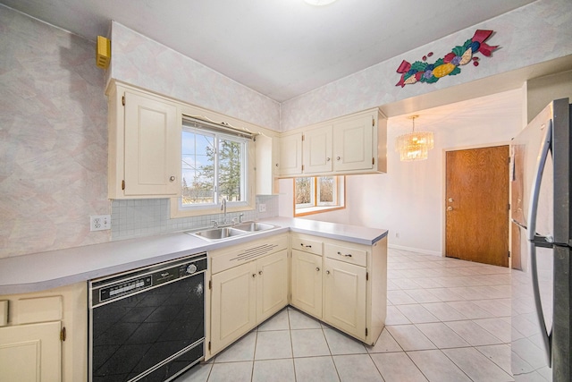 2771 Park Dr, Adrian, MI 49221 - kitchen with a sink, freestanding refrigerator, a peninsula, a chandelier, and black dishwasher