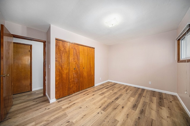 2771 Park Dr, Adrian, MI 49221 - unfurnished bedroom featuring a closet, light wood-style floors, and baseboards