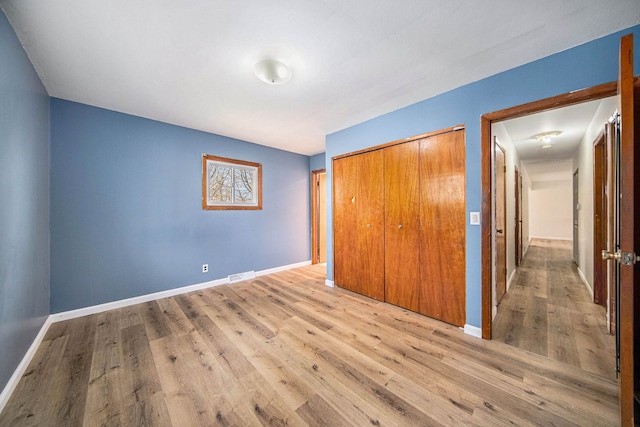 2771 Park Dr, Adrian, MI 49221 - unfurnished bedroom with baseboards, visible vents, wood finished floors, and a closet
