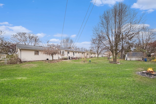 2771 Park Dr, Adrian, MI 49221 - view of yard featuring a storage shed, a fire pit, and an outbuilding