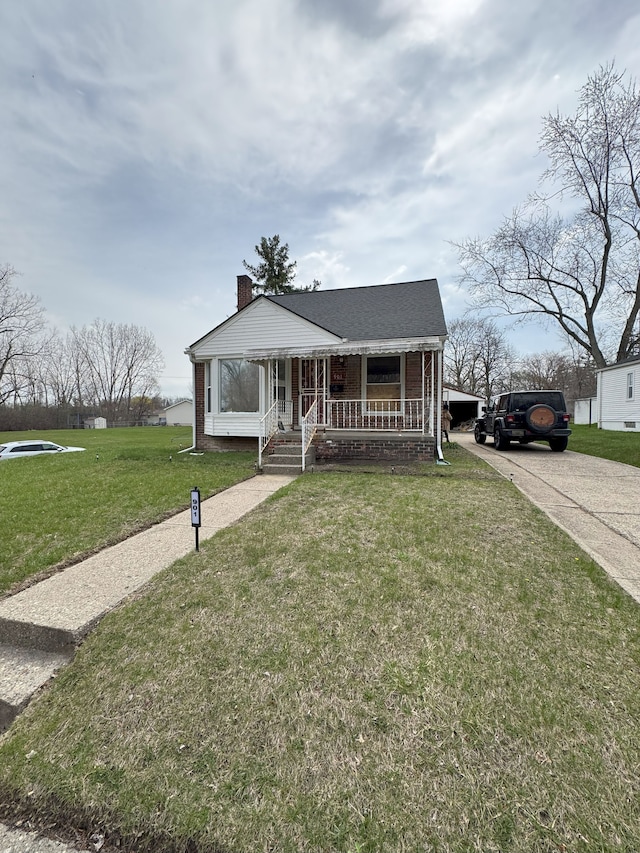bungalow-style house featuring a chimney, a front lawn, concrete driveway, covered porch, and brick siding